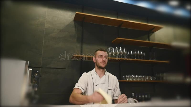Νέος τύπος στην ομοιόμορφη ζύμη πιτσών περιστροφής και ρίψης αρχιμαγείρων στην κουζίνα εστιατορίων σε σε αργή κίνηση