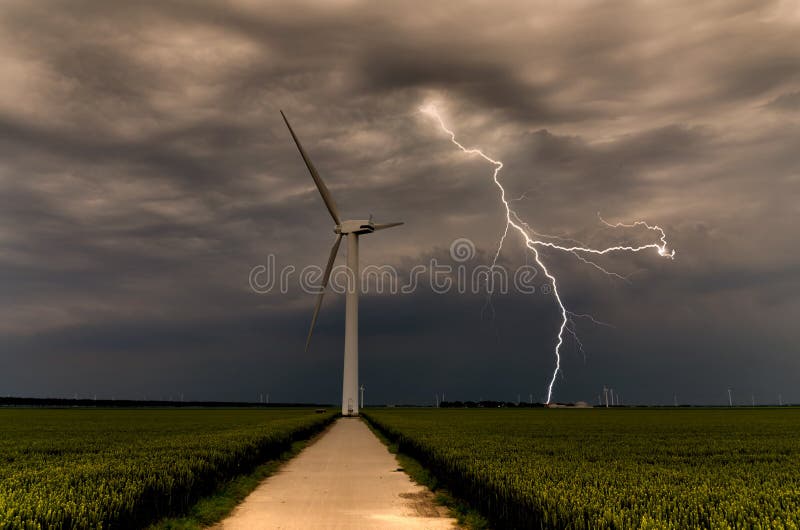 Strong lightning threatening wind turbines in a crop field during daylight. With brownish turbulent sky. Strong lightning threatening wind turbines in a crop field during daylight. With brownish turbulent sky.