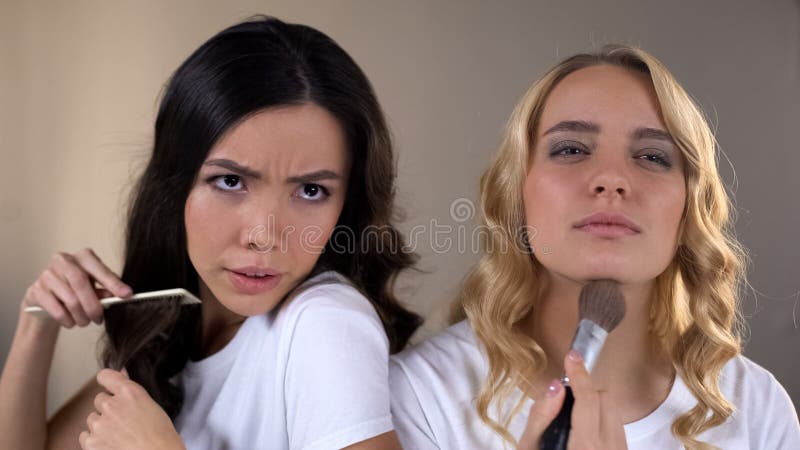 Να ισχύσει δύο κοριτσιών αποτελεί, παλεύοντας για τη θέση μπροστά από τον καθρέφτη, ανταγωνισμός, φθόνος στοκ εικόνα Να ισχύσει δύο κοριτσιών αποτελεί, παλεύοντας για τη θέση μπροστά από τον καθρέφτη, ανταγωνισμός, φθόνος στοκ εικόνα