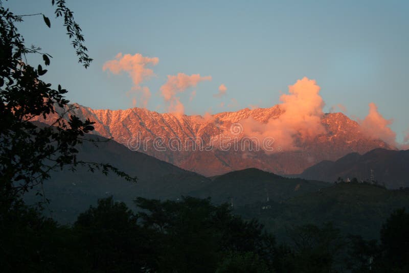 Orange-red glowing sunset light on dhauladhar himalayan mountain ranges as viewed from dharamsala town of Kangra, Hiamchal Pradesh, India. Orange-red glowing sunset light on dhauladhar himalayan mountain ranges as viewed from dharamsala town of Kangra, Hiamchal Pradesh, India