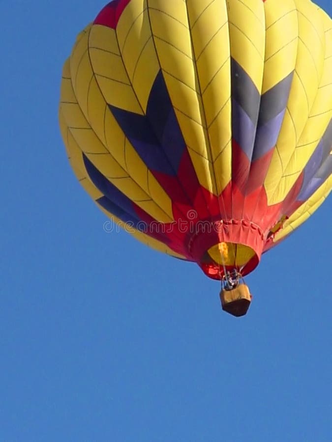 Flaming Hot Air Ballon in flight against bright blue sky. Flaming Hot Air Ballon in flight against bright blue sky