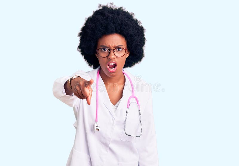 Young african american woman wearing doctor coat and stethoscope pointing displeased and frustrated to the camera, angry and furious with you. Young african american woman wearing doctor coat and stethoscope pointing displeased and frustrated to the camera, angry and furious with you