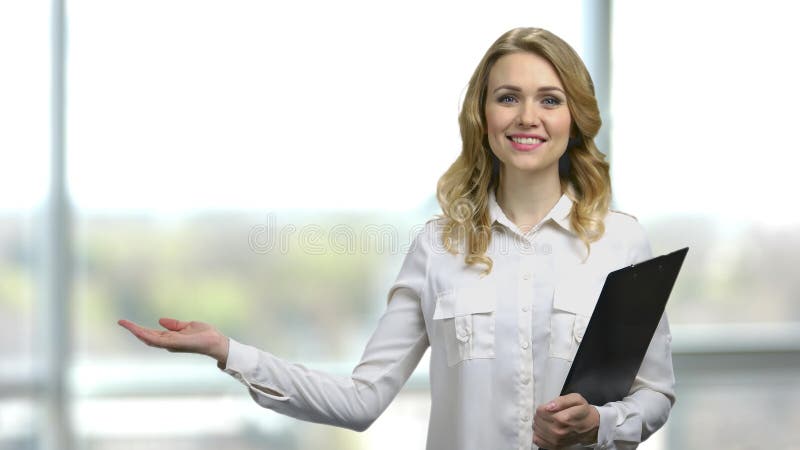 νεαρή γυναίκα με πρόχειρο που δείχνει ανοιχτό χέρι με χώρο αντιγραφής. απόθεμα βίντεο