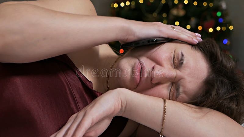 νεαρή γυναίκα ξυπνάει από ένα κινητό τηλέφωνο με πονοκέφαλο και πονοκέφαλο