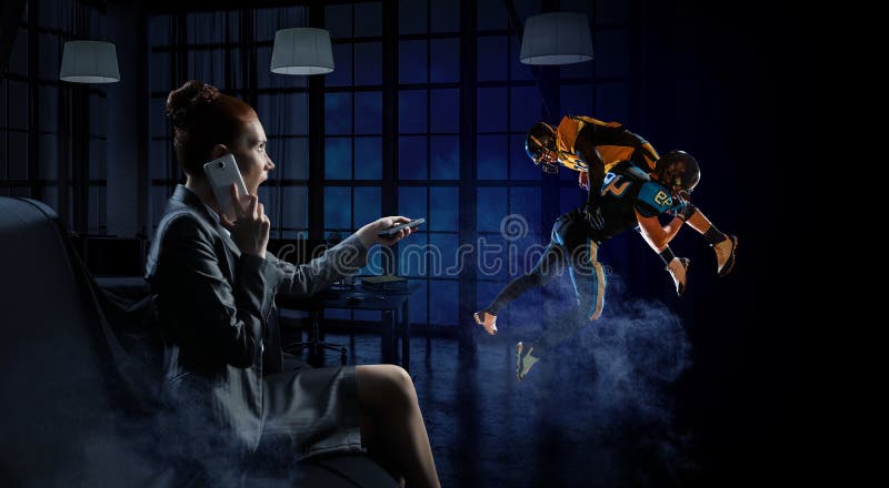 νεαρή γυναίκα που παρακολουθεί αμερικάνικο ποδόσφαιρο. μεικτά μέσα στοκ φωτογραφίες