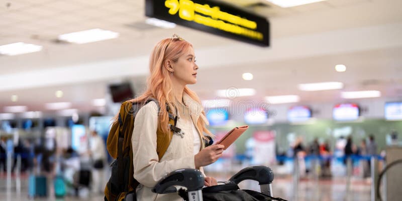 νεαρή γυναίκα που ταξιδεύει στο σύγχρονο αεροδρόμιο με αποσκευές και tablet έτοιμα για περιπέτεια και εξερεύνηση στοκ φωτογραφίες