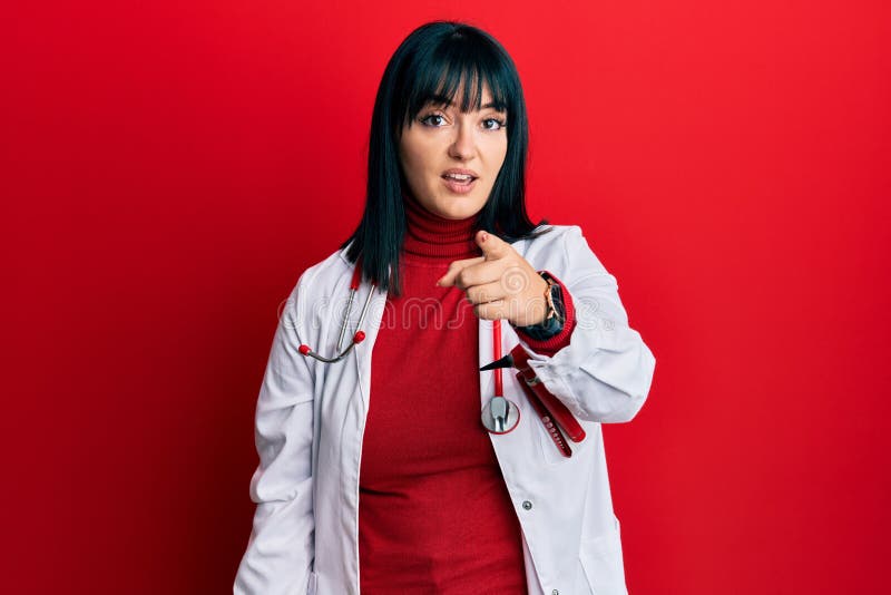 Young hispanic woman wearing doctor uniform and stethoscope pointing displeased and frustrated to the camera, angry and furious with you. Young hispanic woman wearing doctor uniform and stethoscope pointing displeased and frustrated to the camera, angry and furious with you