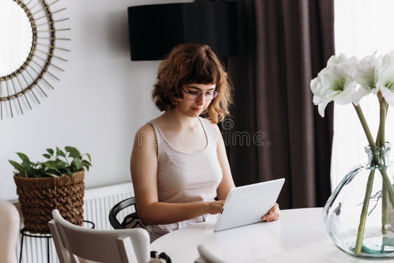 νεαρή κοπέλα που σπουδάζει online. κατ' οίκον εκπαίδευση και κατ' οίκον διδασκαλία. online μαθήματα σε ψηφιακό tablet στοκ εικόνα