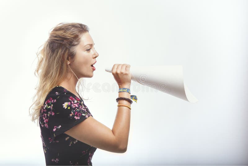 Model using a cone made of paper as if it were a megaphone, In studio with a white background. Model using a cone made of paper as if it were a megaphone, In studio with a white background