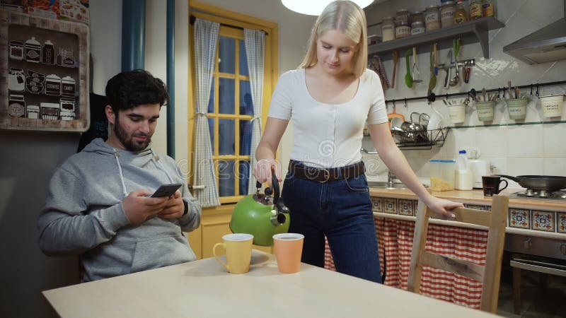 νεαρό ζευγάρι που πίνει τσάι μαζί στην κουζίνα στοκ εικόνα με δικαίωμα ελεύθερης χρήσης
