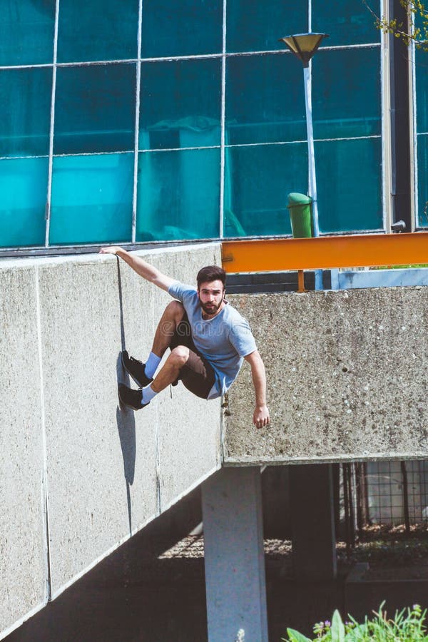 Νεαρός άνδρας που κάνει parkour στην πόλη στοκ εικόνες