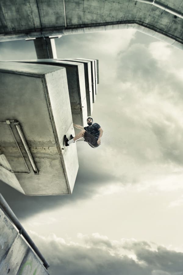 Νεαρός άνδρας που κάνει parkour στην πόλη στοκ εικόνες