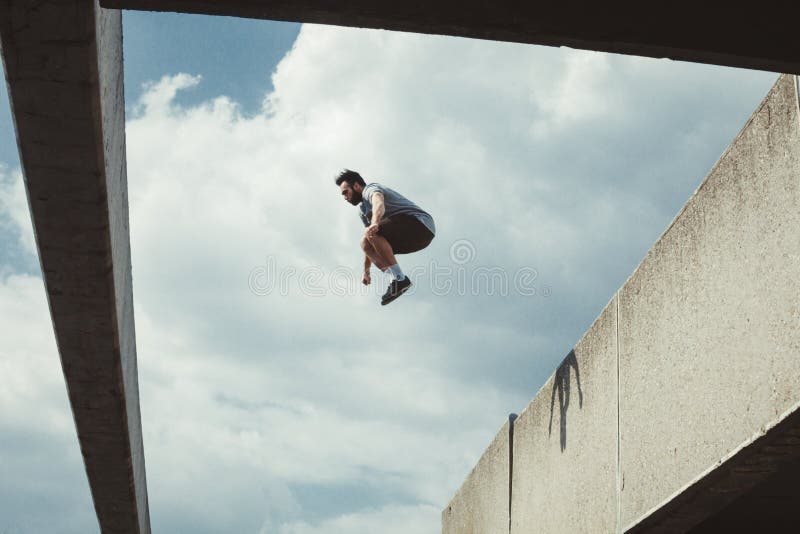 Νεαρός άνδρας που κάνει parkour το άλμα στην πόλη στοκ φωτογραφία