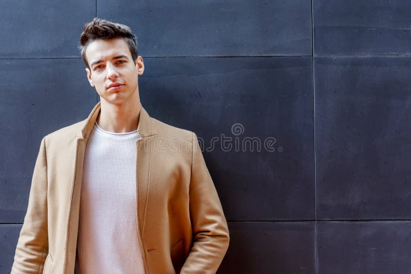 Νεαρός άνδρας που φορά τα χειμερινά ενδύματα στην οδό Νέος τύπος με το σύγχρονο hairstyle με το παλτό, το τζιν παντελόνι και άσπρ στοκ εικόνες Νεαρός άνδρας που φορά τα χειμερινά ενδύματα στην οδό Νέος τύπος με το σύγχρονο hairstyle με το παλτό, το τζιν παντελόνι και άσπρ στοκ εικόνες