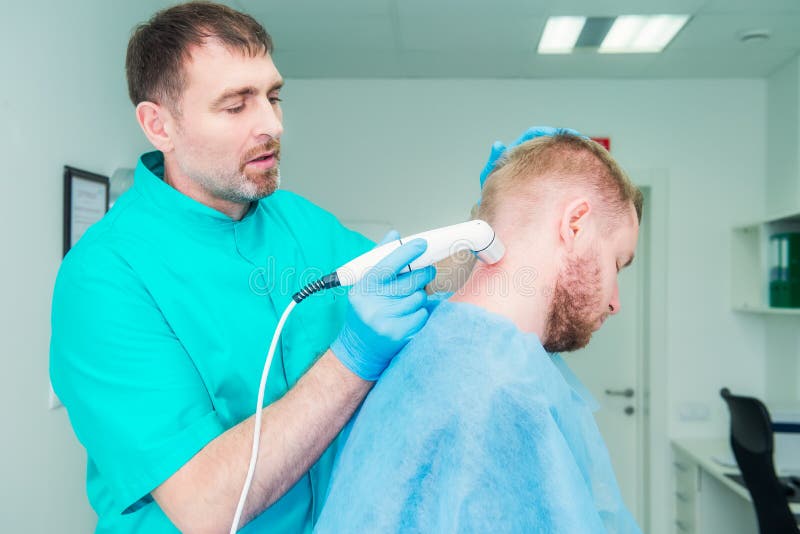 Νεαρός άνδρας στη φυσιοθεραπεία που λαμβάνει το μασάζ θεραπείας λέιζερ Ένα chiropractor μεταχειρίζεται την αυχενική σπονδυλική στ στοκ φωτογραφίες με δικαίωμα ελεύθερης χρήσης Νεαρός άνδρας στη φυσιοθεραπεία που λαμβάνει το μασάζ θεραπείας λέιζερ Ένα chiropractor μεταχειρίζεται την αυχενική σπονδυλική στ στοκ φωτογραφίες με δικαίωμα ελεύθερης χρήσης