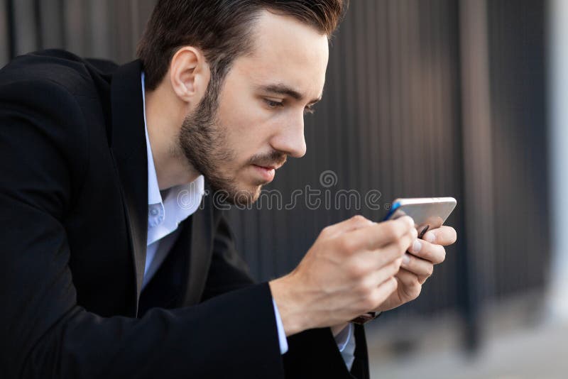 Νεαρός επιχειρηματίας ψάχνει στο κινητό smartphone, παίζει Εξάρτηση από τις πληροφορίες στοκ εικόνες με δικαίωμα ελεύθερης χρήσης