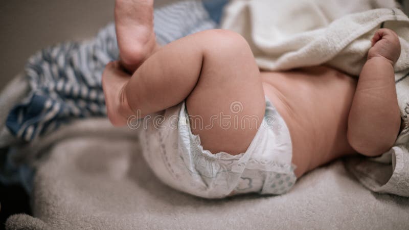 Νεογέννητα μωρά πόδια σε πάνα, ξαπλωμένα σε λευκό κρεβάτι στοκ φωτογραφίες Νεογέννητα μωρά πόδια σε πάνα, ξαπλωμένα σε λευκό κρεβάτι στοκ φωτογραφίες