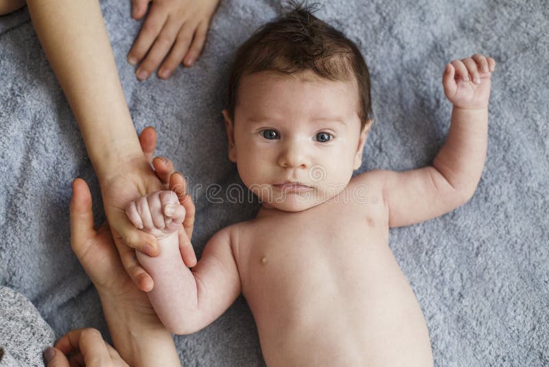 Νεογέννητο γυμνό όμορφο αγοράκι που βρίσκεται και που κοιτάζει στο γκρίζο φύλλο, τοπ άποψη στοκ εικόνα με δικαίωμα ελεύθερης χρήσης Νεογέννητο γυμνό όμορφο αγοράκι που βρίσκεται και που κοιτάζει στο γκρίζο φύλλο, τοπ άποψη στοκ εικόνα με δικαίωμα ελεύθερης χρήσης