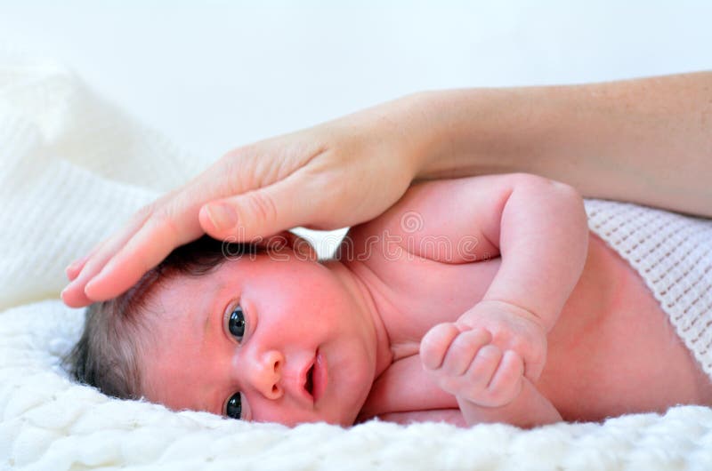 Hand of a young mother t×uch her newborn baby (3 week old).copyspace. Hand of a young mother t×uch her newborn baby (3 week old).copyspace