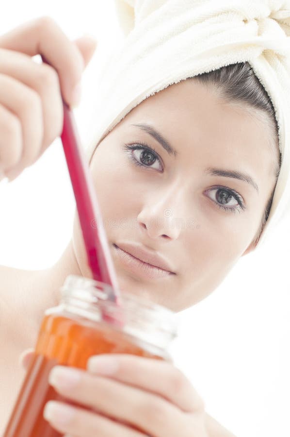 Beautiful girl with a jar of honey in her hands and a towel on her head (selective focus on her face). Beautiful girl with a jar of honey in her hands and a towel on her head (selective focus on her face)