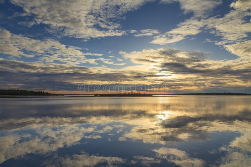 Cloudy sky reflected in the lake at sunset. Cloudy sky reflected in the lake at sunset