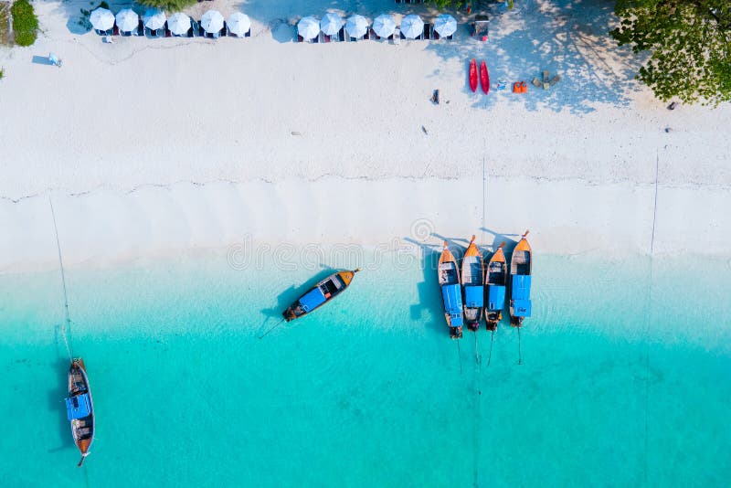 νησί koh lipe νότια ταϊλάνδη με έγχρωμο ωκεανό και λευκή αμμώδης παραλία στο ko lipe. πολύχρωμα παραγαδιάρικα σκάφη στον γαλάζιο ωκεανό του νησιού koh lipe νότια ταϊλάνδη με τον έγχρωμο ωκεανό turqouse και τη λευκή αμμώδη παραλία στο ko lipe.