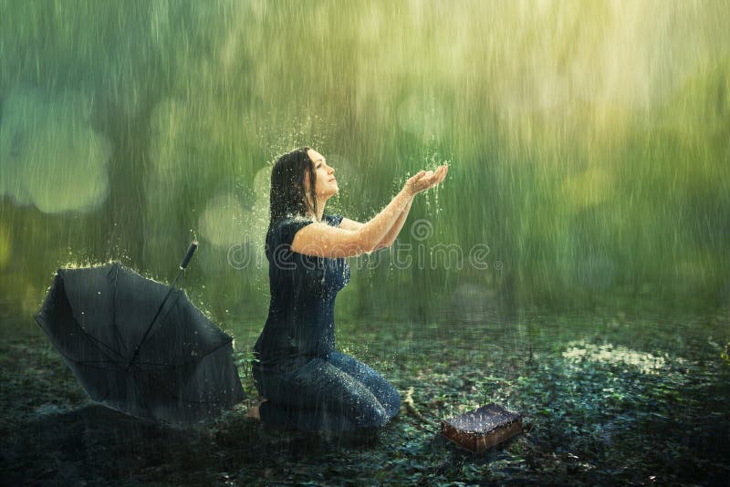 A woman enjoys a rain shower in the forest. A woman enjoys a rain shower in the forest.