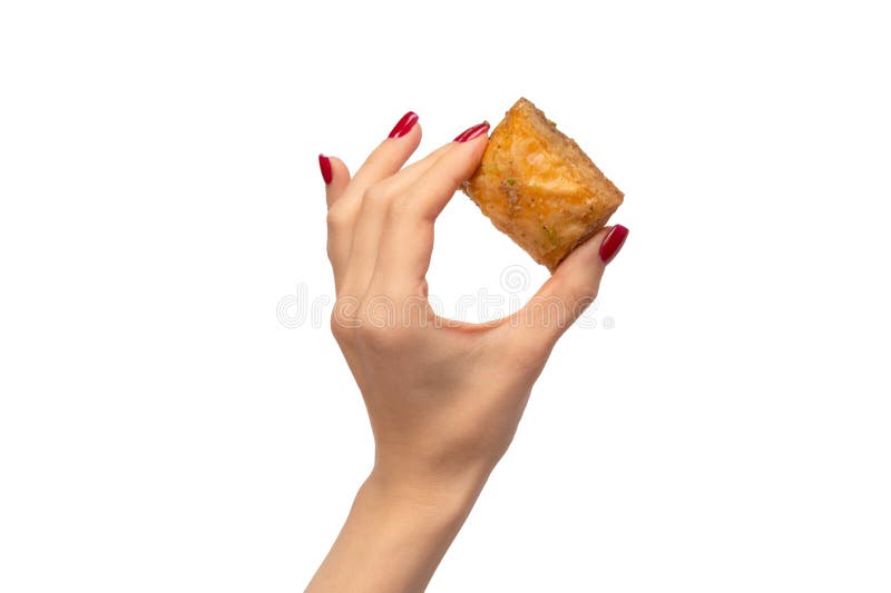 νόστιμο γλυκό baklava σε γυναίκα χέρι με κόκκινα νύχια απομονωμένα σε λευκό φόντο. προβολή επάνω