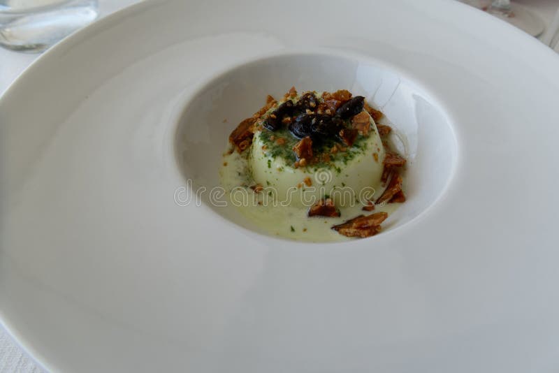νόστιμο ιταλικό επιδόρπιο που ονομάζεται panna cotta αρωματισμένο με σάλτσα πέστο που έχει γευτεί με καραμέλες και ελιές ταγκιάσκα στοκ εικόνα με δικαίωμα ελεύθερης χρήσης