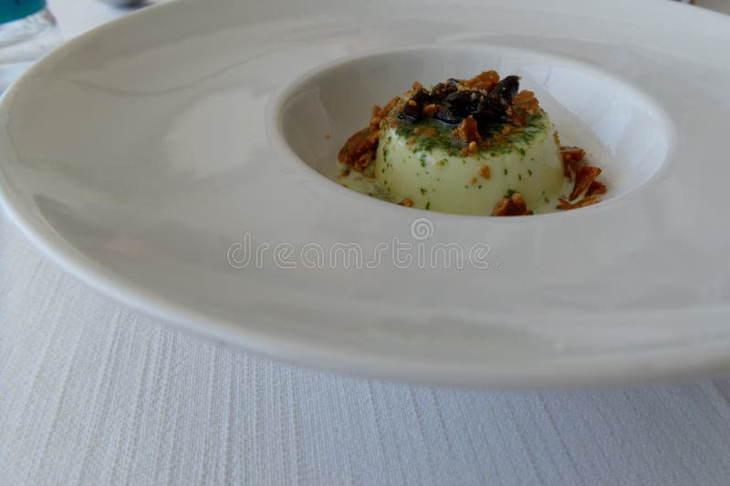 νόστιμο ιταλικό επιδόρπιο που ονομάζεται panna cotta αρωματισμένο με σάλτσα πέστο που έχει γευτεί με καραμέλες και ελιές ταγκιάσκα στοκ εικόνα