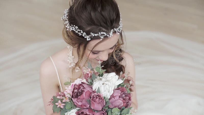 Νύφη brunette κινηματογραφήσεων σε πρώτο πλάνο με το γάμο μόδας hairstyle και makeup