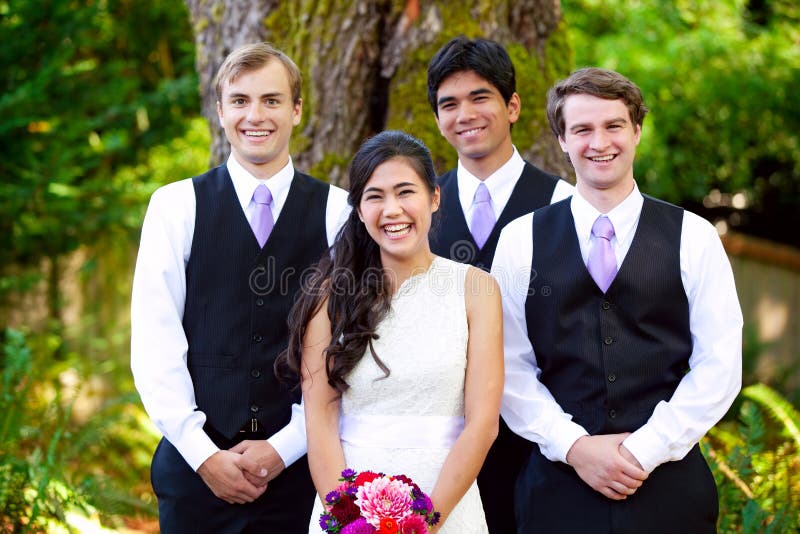 Νύφη που στέκεται με τρεις groomsmen της υπαίθρια κάτω από το μεγάλο tre στοκ φωτογραφίες με δικαίωμα ελεύθερης χρήσης Νύφη που στέκεται με τρεις groomsmen της υπαίθρια κάτω από το μεγάλο tre στοκ φωτογραφίες με δικαίωμα ελεύθερης χρήσης
