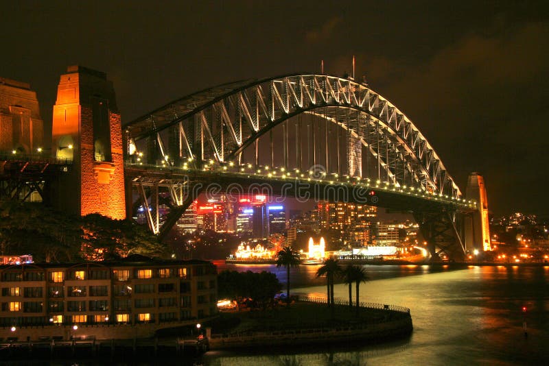 The Sydney Harbour Bridge illuminated at night with lots of city lights on the background. The Sydney Harbour Bridge illuminated at night with lots of city lights on the background.