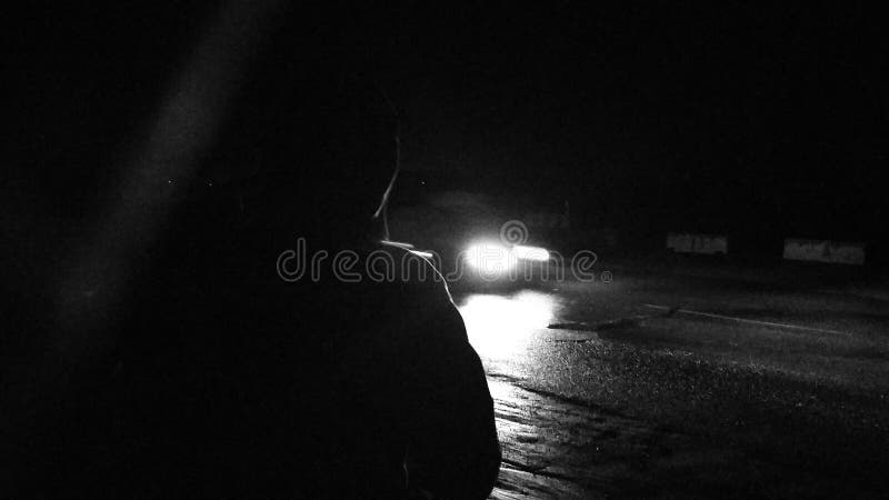 Ξένος στη νύχτα που περιμένει ένα αυτοκίνητο στοκ φωτογραφία Ξένος στη νύχτα που περιμένει ένα αυτοκίνητο στοκ φωτογραφία