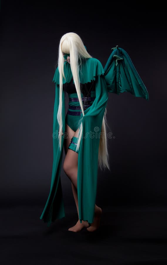 Blond girl posing in green fury cosplay costume anime character. Blond girl posing in green fury cosplay costume anime character