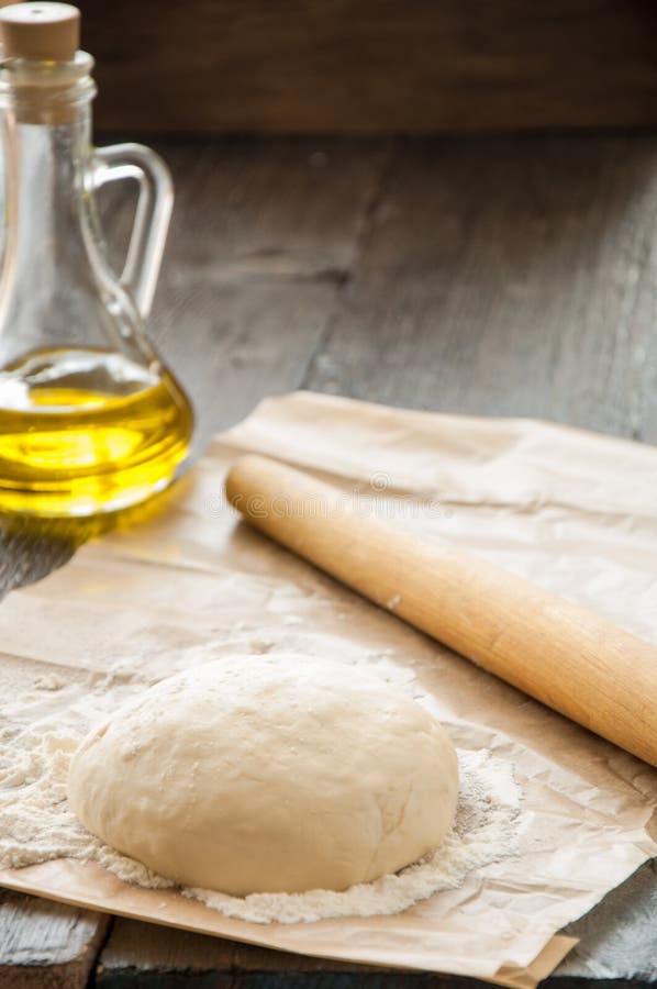 Ξύλινη κυλώντας καρφίτσα με την πρόσφατα έτοιμη ζύμη για την πίτσα στοκ φωτογραφία με δικαίωμα ελεύθερης χρήσης Ξύλινη κυλώντας καρφίτσα με την πρόσφατα έτοιμη ζύμη για την πίτσα στοκ φωτογραφία με δικαίωμα ελεύθερης χρήσης