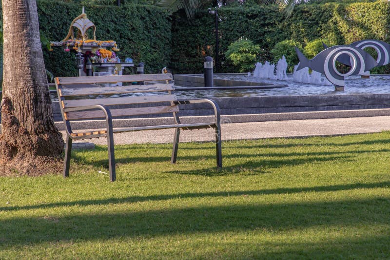 ξύλινες πάγκοι στο γρασίδι σε μια σκοτεινή περιοχή του πάρκου στοκ φωτογραφία με δικαίωμα ελεύθερης χρήσης