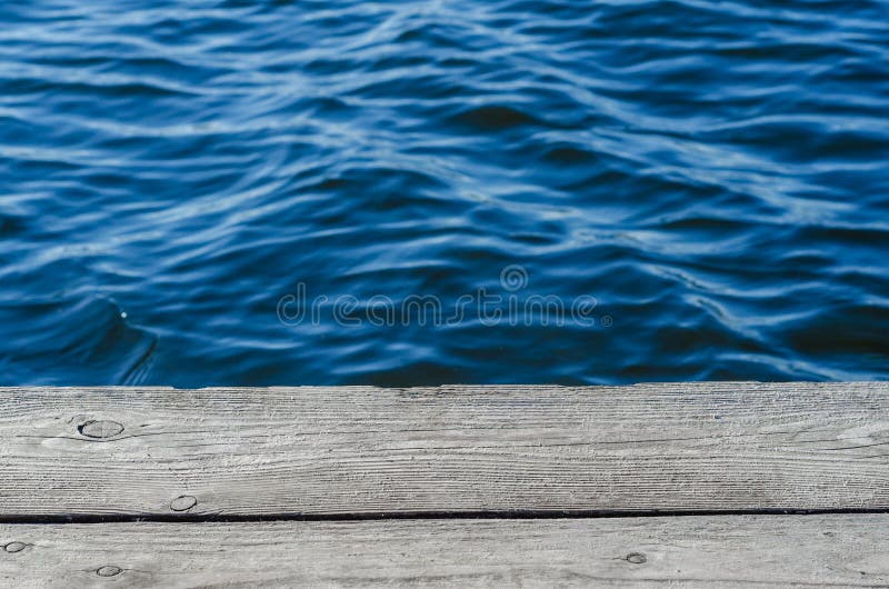 Ξύλινες σανίδες, λιμενοβραχίονας στην ακτή, μπλε νερό, κύματα στοκ εικόνες