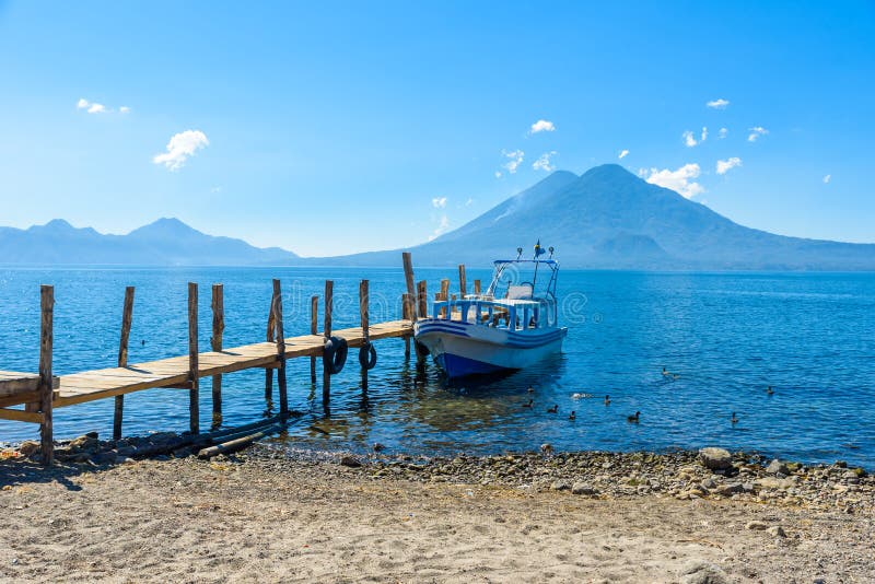 Ξύλινη αποβάθρα στη λίμνη Atitlan στην παραλία σε Panajachel, Γουατεμάλα Με το όμορφο τοπίο τοπίων των ηφαιστείων Toliman, Atitla στοκ εικόνα Ξύλινη αποβάθρα στη λίμνη Atitlan στην παραλία σε Panajachel, Γουατεμάλα Με το όμορφο τοπίο τοπίων των ηφαιστείων Toliman, Atitla στοκ εικόνα