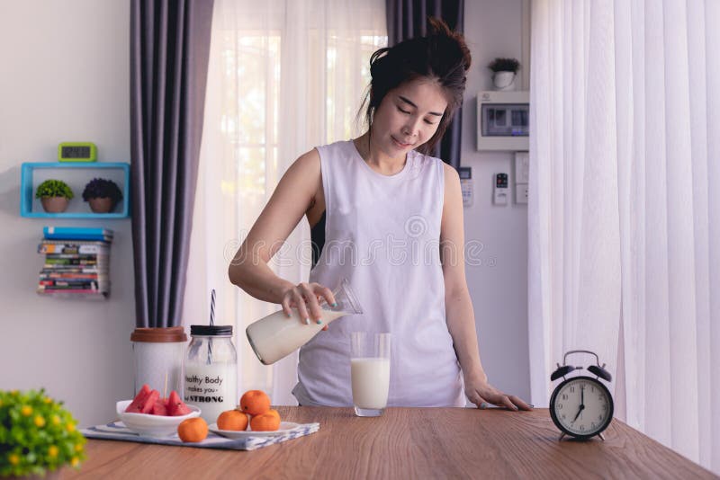 Ξύλινος πίνακας με το νέο ασιατικό χύνοντας γάλα γυναικών