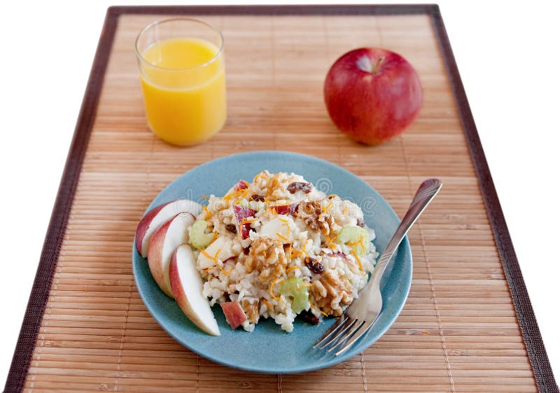 One plate of apple walnut salad with basmati rice, a glass of orange juice and apple on the side. One plate of apple walnut salad with basmati rice, a glass of orange juice and apple on the side