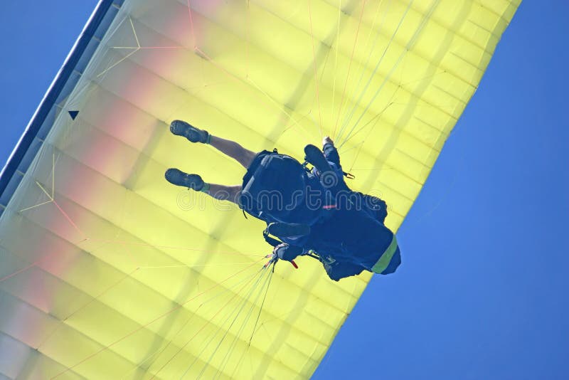 Ο Tandem Paraglider πετάει με μπλε ουρανό στοκ εικόνα Ο Tandem Paraglider πετάει με μπλε ουρανό στοκ εικόνα