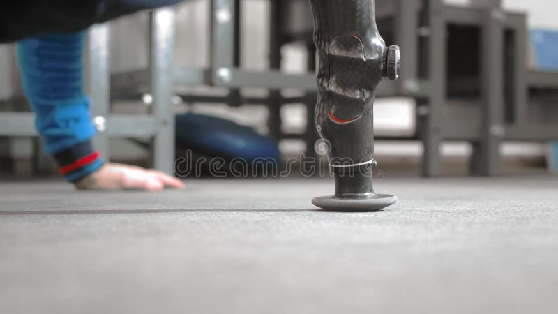 Ο αθλητής με προσθετικό χέρι σπρώχνει έξω Ασκεί στο πάτωμα ενώ ξαπλώνει Επαγγελματικό προσθετικό χέρι