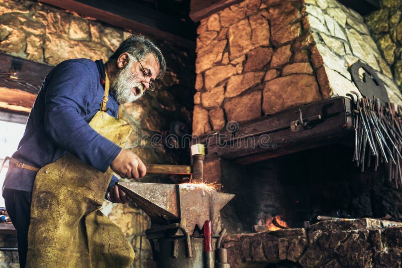 Ο ανώτερος σιδηρουργός σφυρηλατεί το σίδηρο στοκ φωτογραφία με δικαίωμα ελεύθερης χρήσης