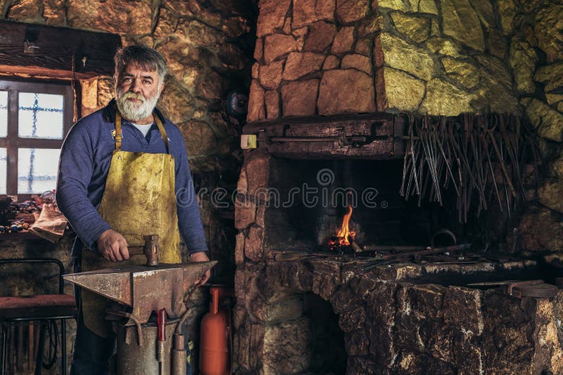Ο ανώτερος σιδηρουργός σφυρηλατεί το σίδηρο στοκ φωτογραφία με δικαίωμα ελεύθερης χρήσης