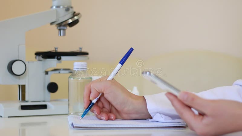 ο γιατρός κάνει σημειώσεις και χρησιμοποιεί smartphone στο εργαστήριο φωτογραφήσεις dolly