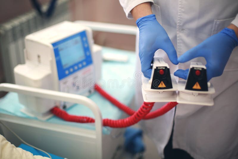 Ο γιατρός κρατά τα defibrillator ηλεκτρόδια Επαναδραστηριοποίηση Ιατρικός εξοπλισμός στοκ φωτογραφίες με δικαίωμα ελεύθερης χρήσης Ο γιατρός κρατά τα defibrillator ηλεκτρόδια Επαναδραστηριοποίηση Ιατρικός εξοπλισμός στοκ φωτογραφίες με δικαίωμα ελεύθερης χρήσης