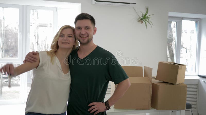 Ο επανεντοπισμός στο νοικιασμένο σπίτι, πορτρέτο των νέων ιδιοκτητών διαμερισμάτων newlyweds παρουσιάζει κλειδιά στο επίπεδο και απόθεμα βίντεο