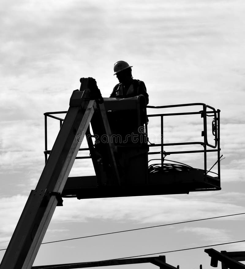 Ο εργάτης οικοδομών γεφυρών χειρίζεται έναν ανελκυστήρα πλατφορμών στοκ φωτογραφίες με δικαίωμα ελεύθερης χρήσης Ο εργάτης οικοδομών γεφυρών χειρίζεται έναν ανελκυστήρα πλατφορμών στοκ φωτογραφίες με δικαίωμα ελεύθερης χρήσης