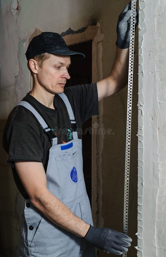 Man fixes a guide to align the walls with stucco in the future. Man fixes a guide to align the walls with stucco in the future